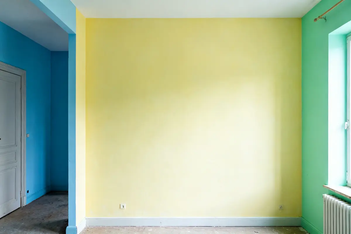 Mur intérieur jaune pale couleur avec encadrement bleu et vert en arrière-plan